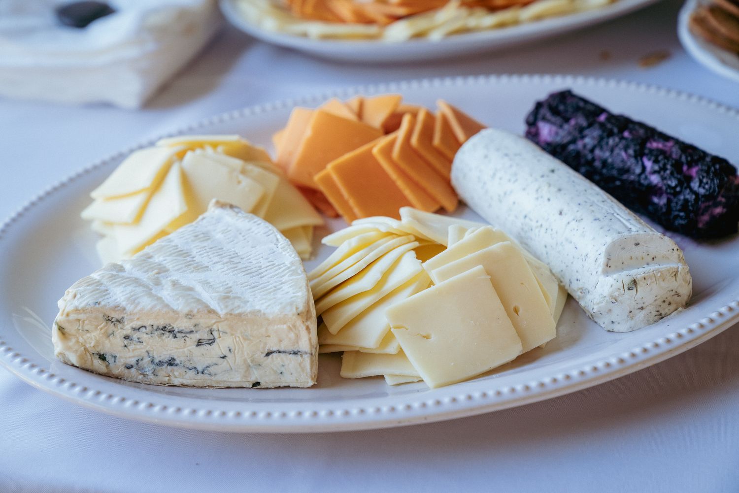 Assorted cheeses on a white platter — Portland commercial food photography.