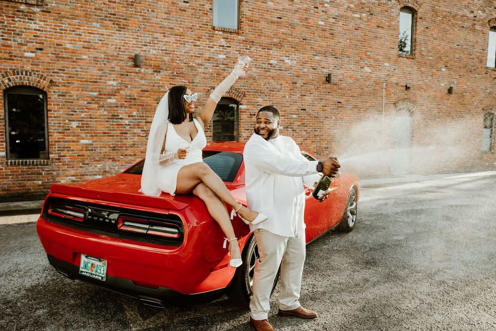 A series of wedding photos captured against a rustic brick wall background featuring a classic red car.