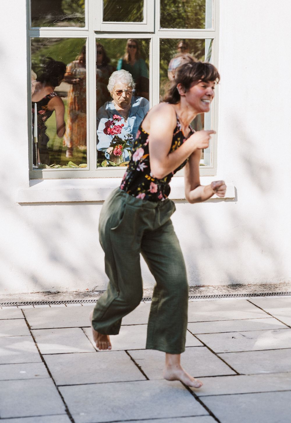 Sequence of four photos showing someone in green overalls bending down to look through white-framed windows.
