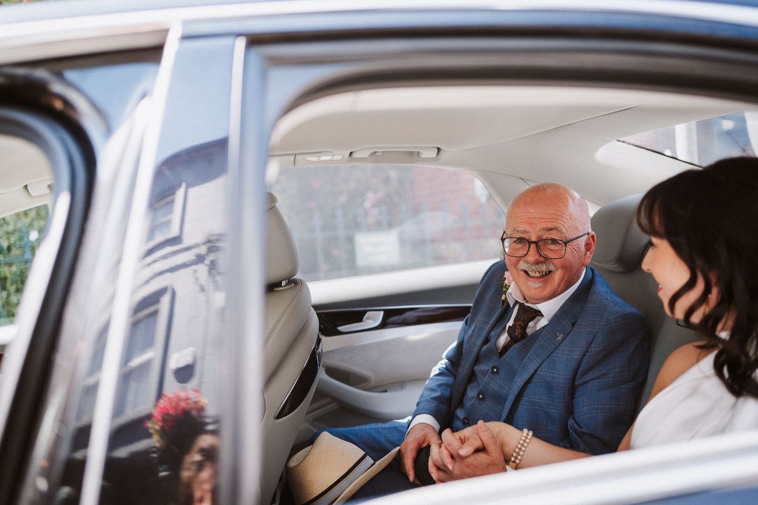 Businessman checks his watch while sitting in the back seat of a luxury car during a commute.