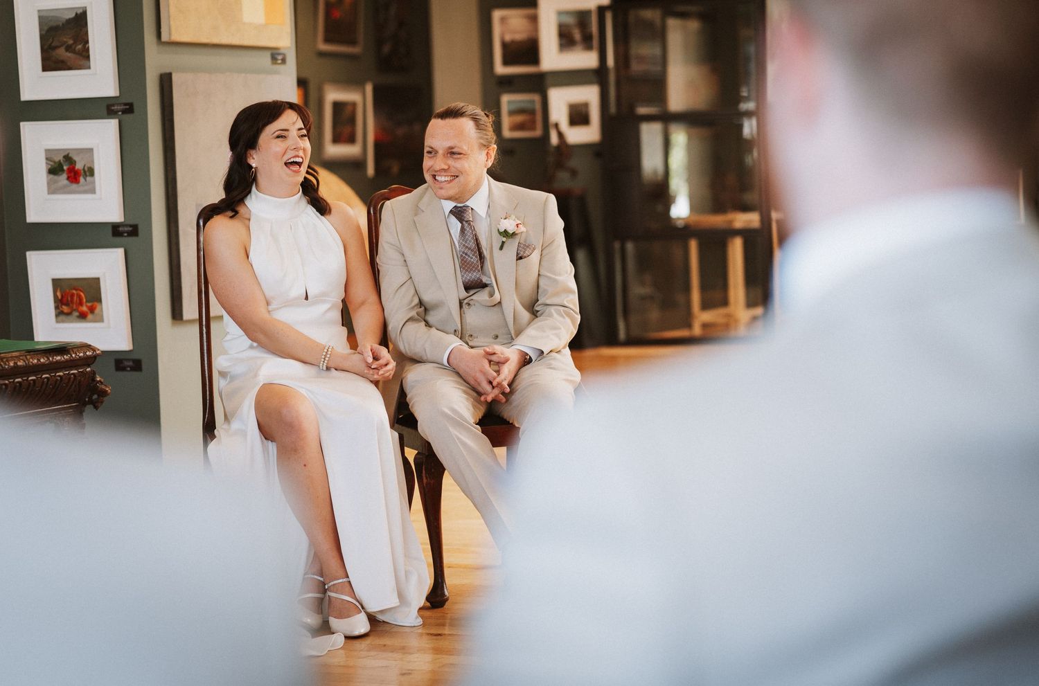 Modern art gallery space with couples and guests gathered among framed photographs.