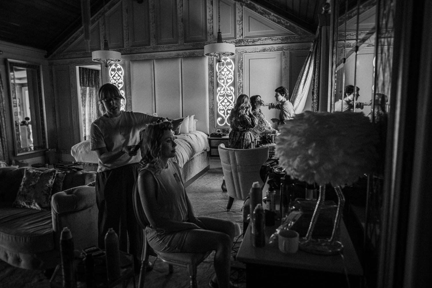Black and white photograph showing a vintage salon interior with ornate details and mirrors.