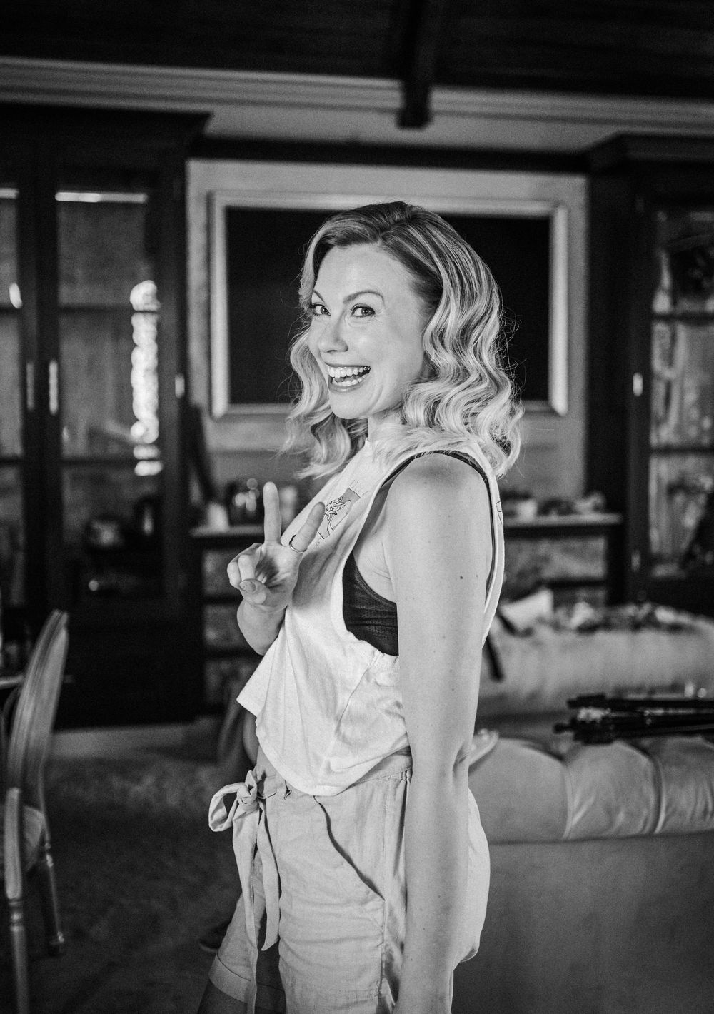 Black and white portrait of woman in formal dress laughing joyfully.