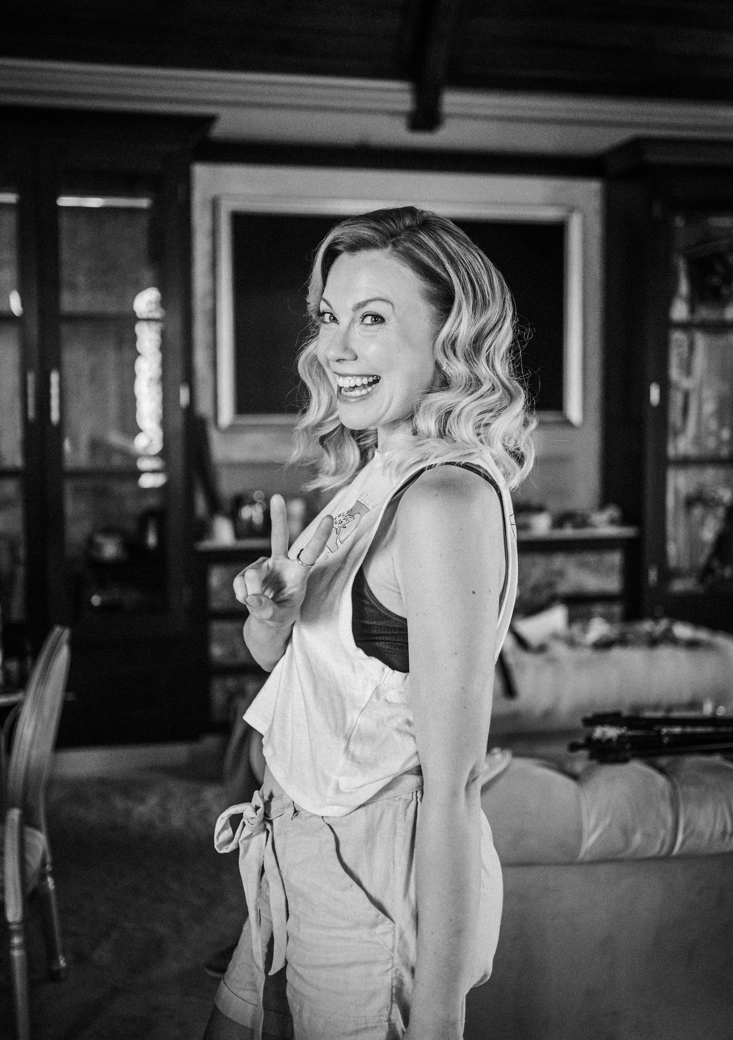 Black and white portrait of woman in formal dress laughing joyfully.