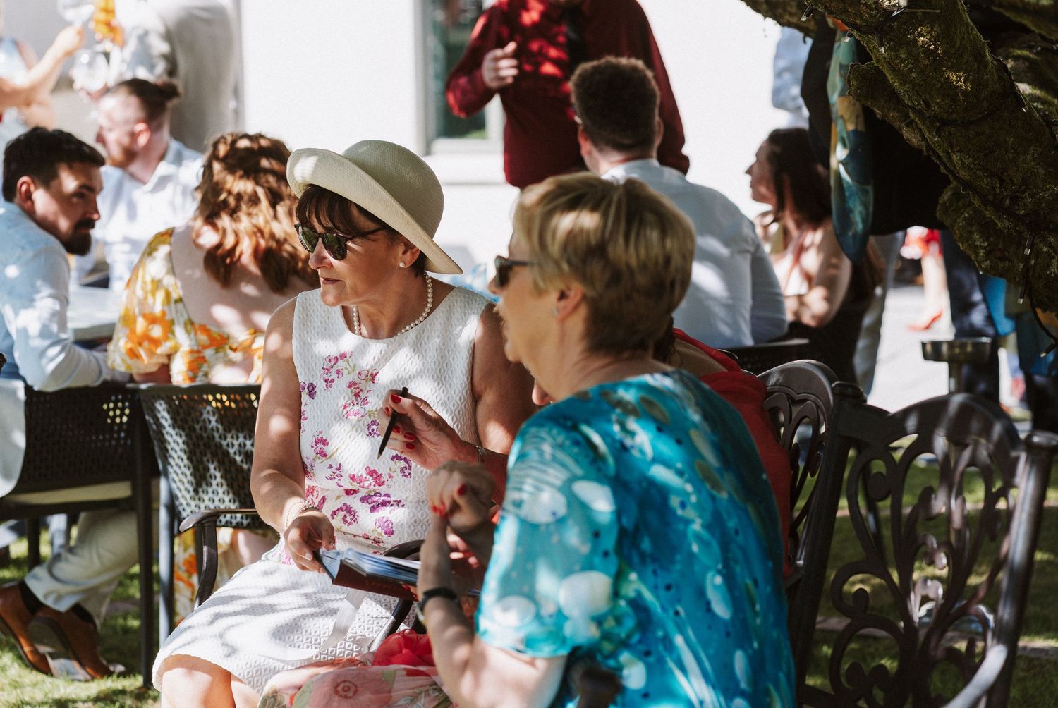 A series of wedding reception photos showing guests eating and celebrating at outdoor tables during daytime.