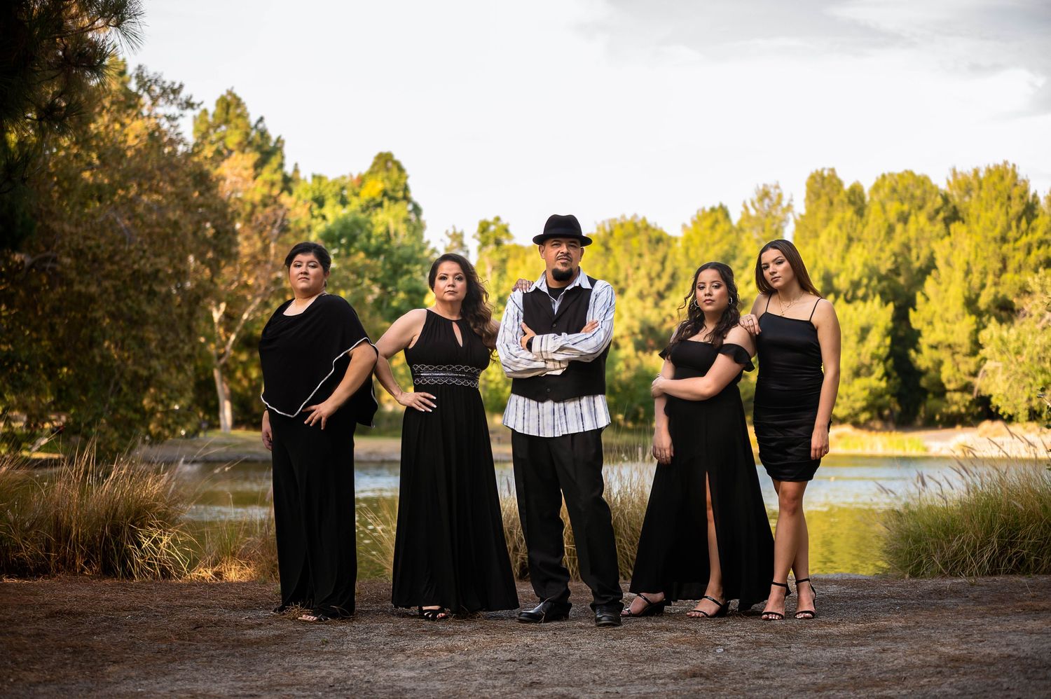 Group portrait session at golden hour with people seated casually outdoors.