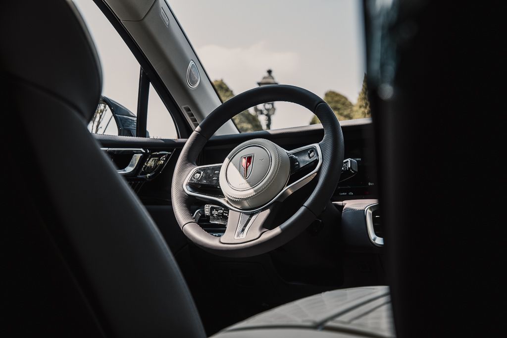 Interior view of a modern car dashboard and steering wheel with digital displays.