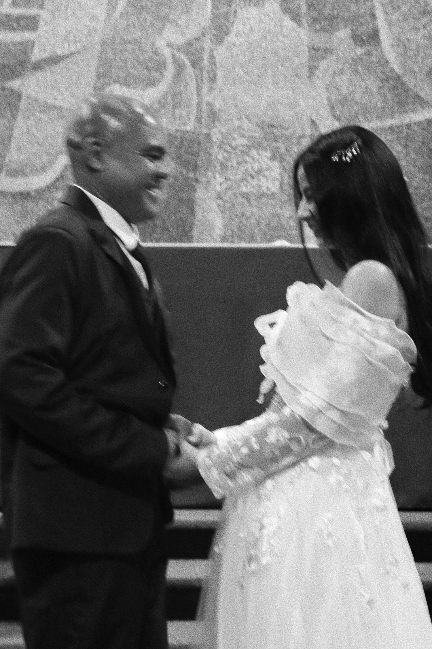 Black and white photo captures wedding couple's side profile during ceremony.