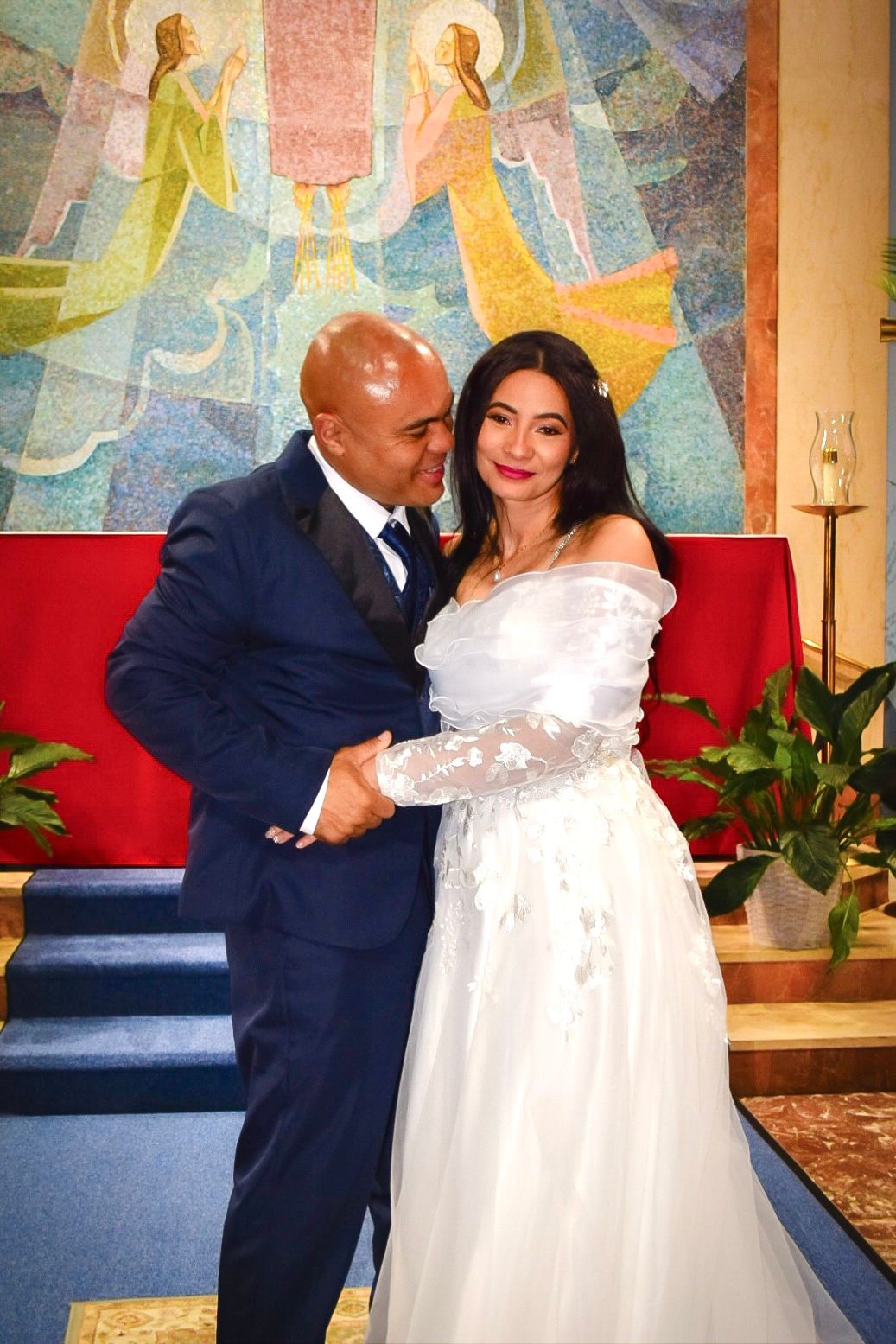 Wedding couple shares an intimate moment in a Catholic church.