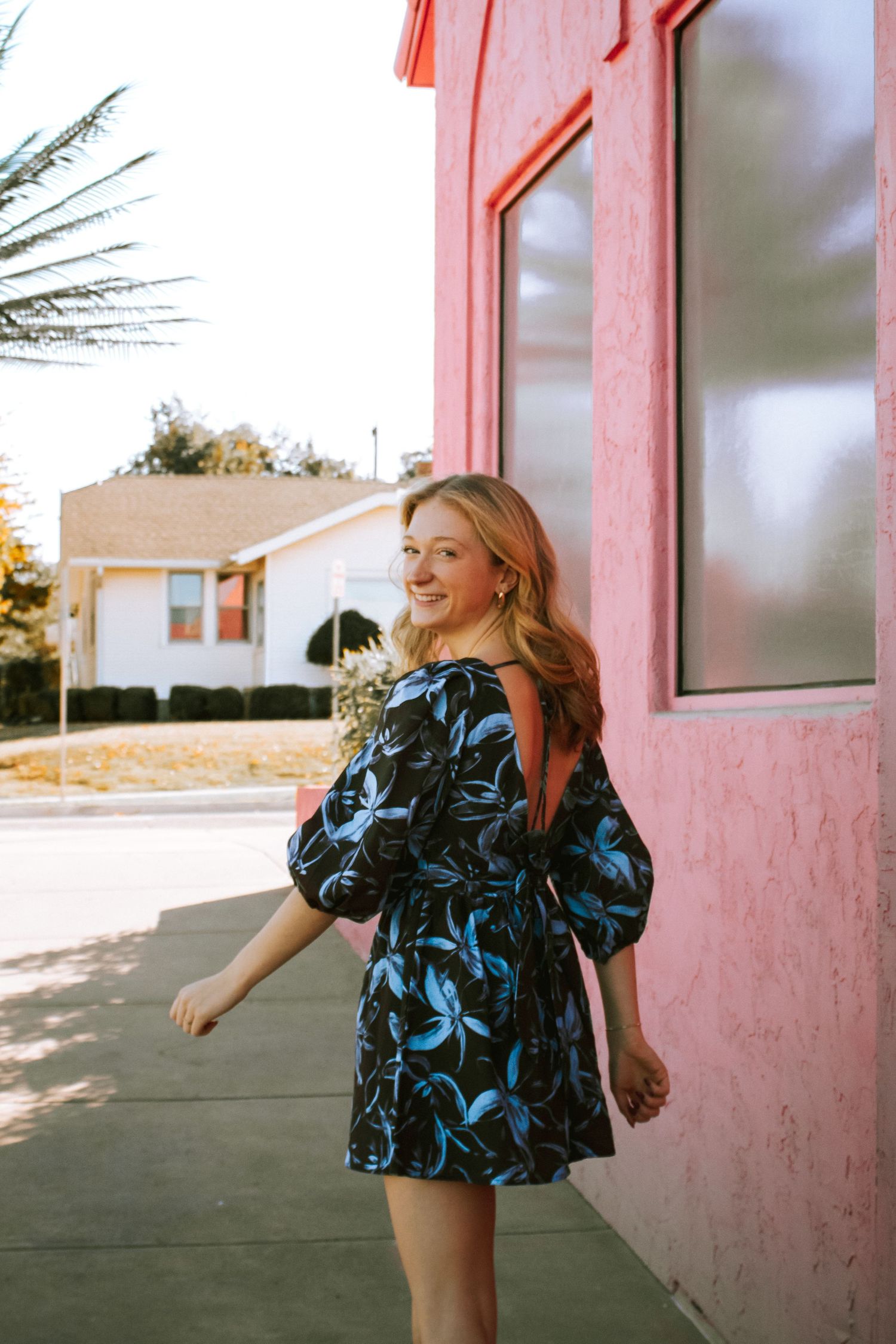 Bishop McGuinness High School Senior Walking In Front of Flamingo Tiki in the Paseo District