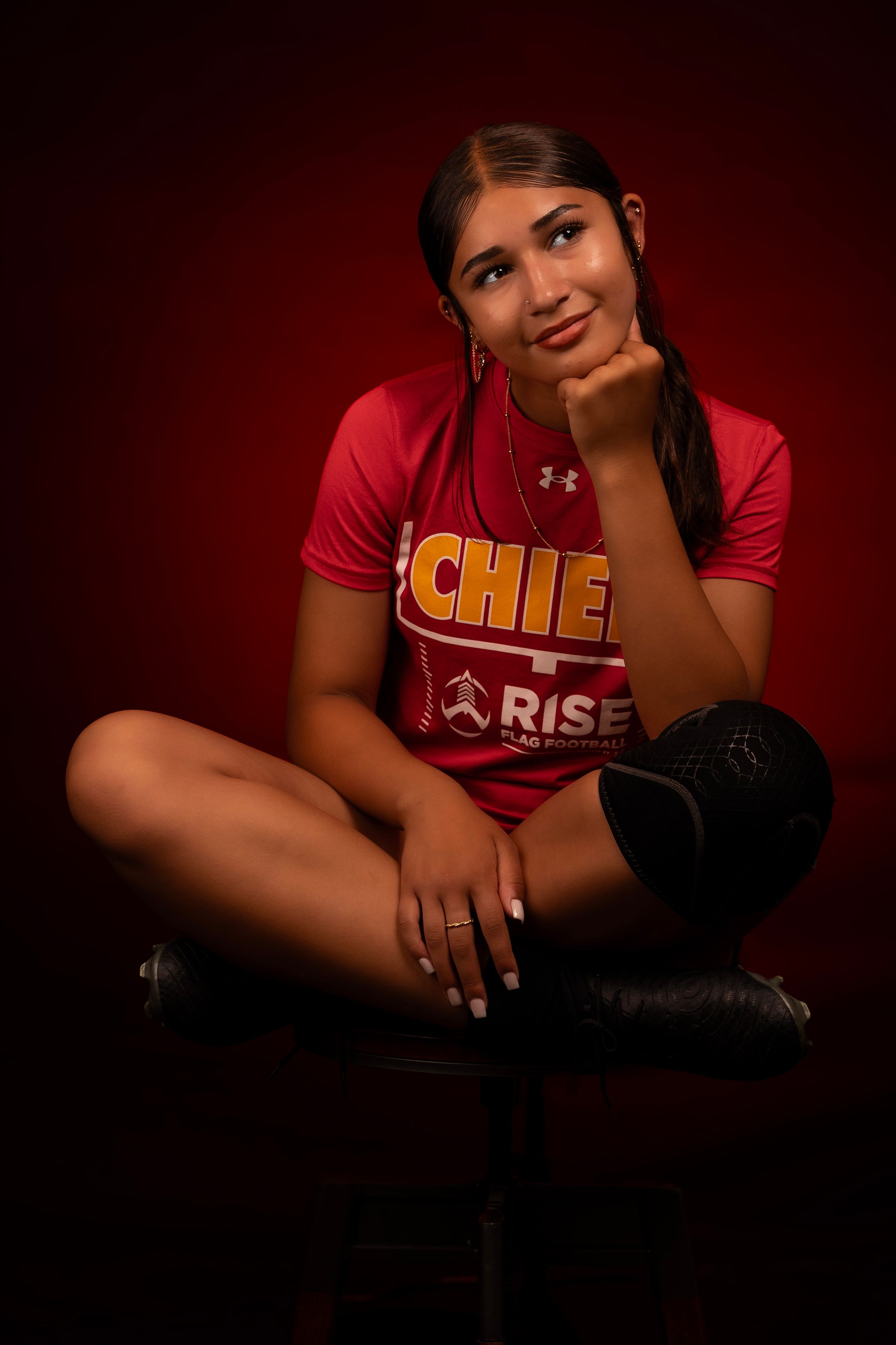 Dramatic sports photo featuring red uniform with gold text against dark background.