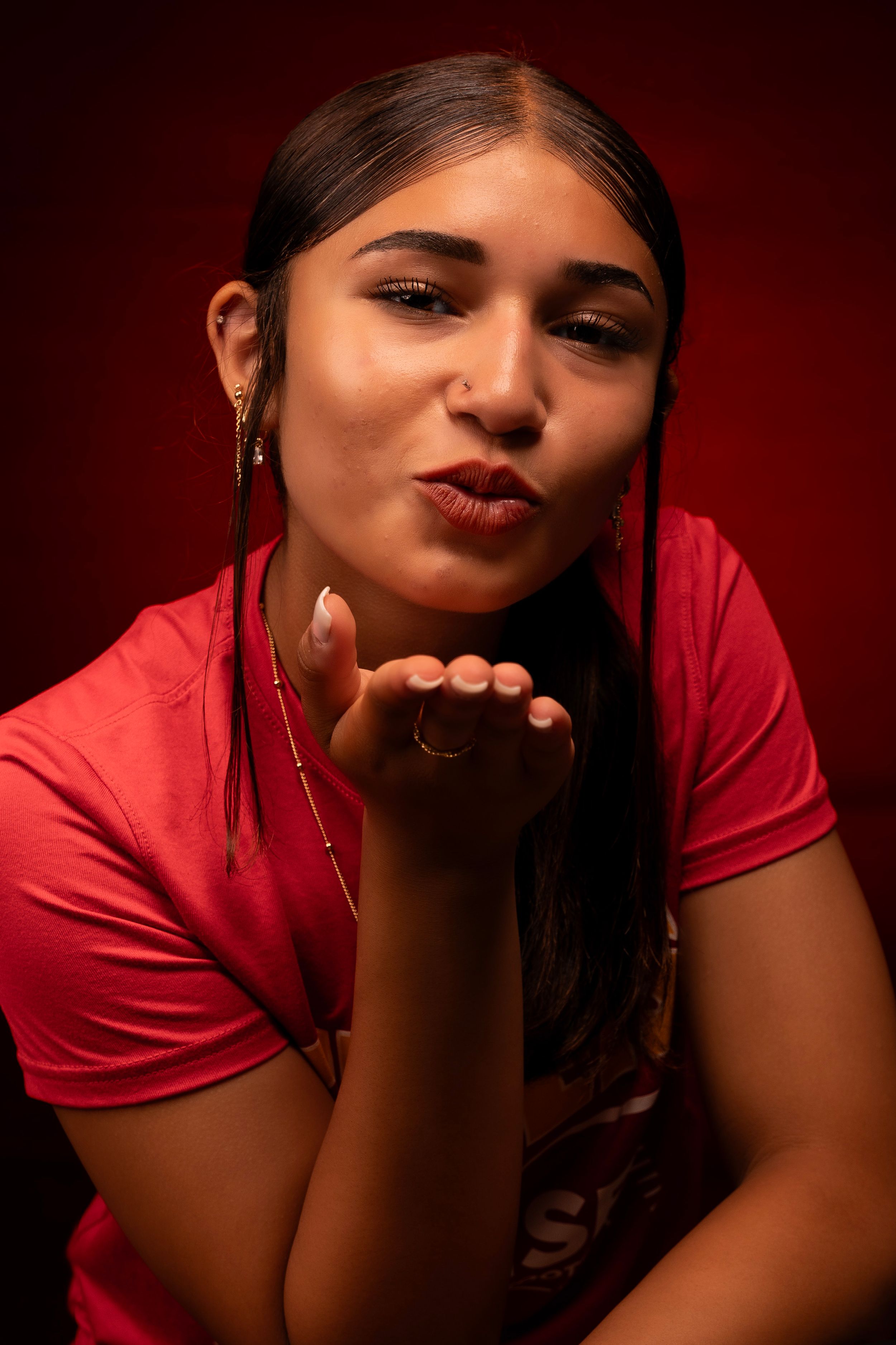 Expressive portrait sequence in red uniform against dramatic burgundy backdrop.
