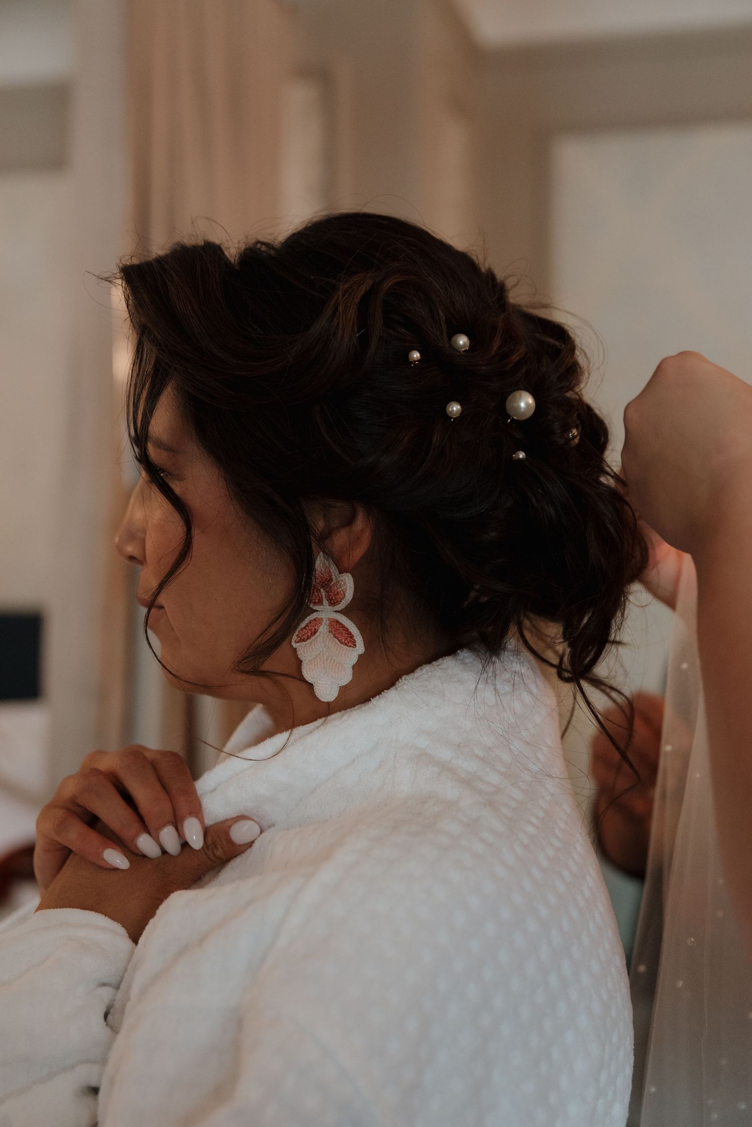 Close-up detail of delicate lace and beading on a white wedding dress.