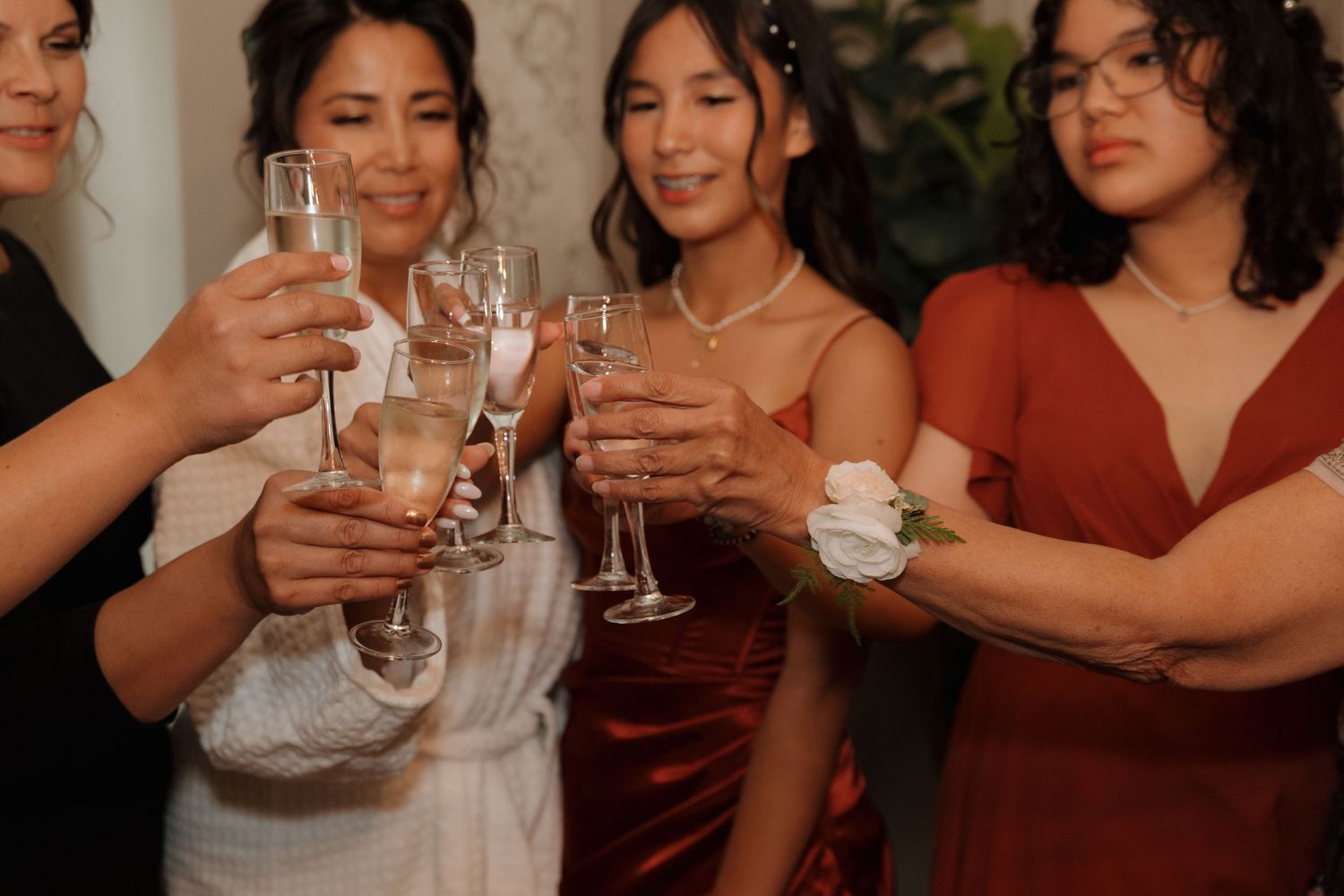 Wedding party guests raise champagne glasses in a celebratory toast at a reception.