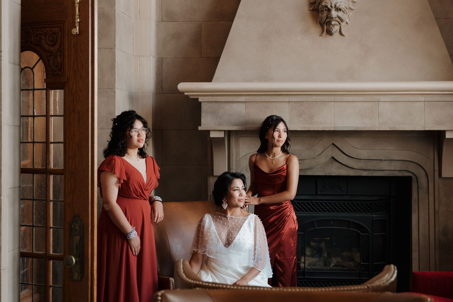 Wedding preparation scene with people in a luxurious room with elegant fireplace.