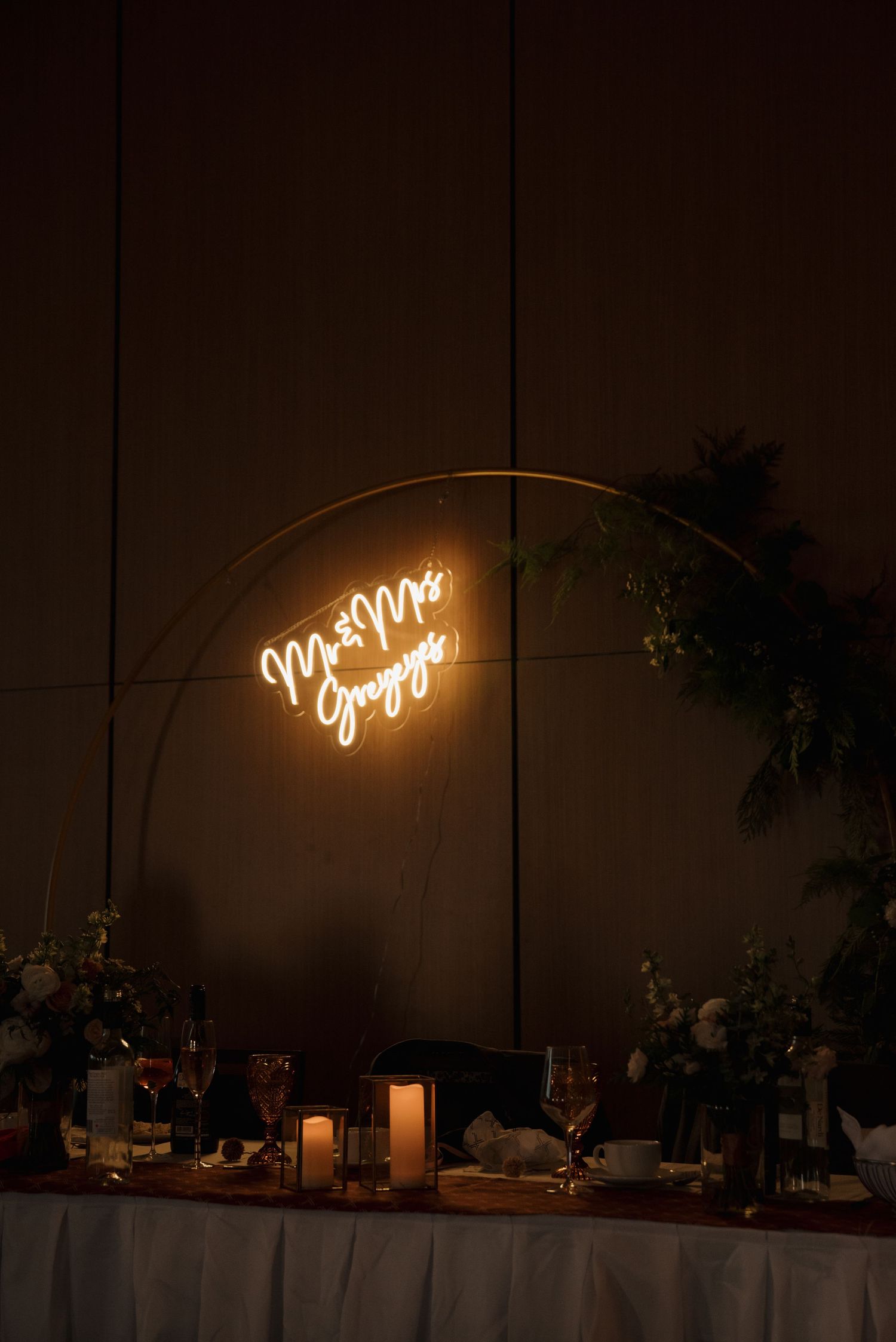 Illuminated neon sign display at wedding reception with dark ambiance.