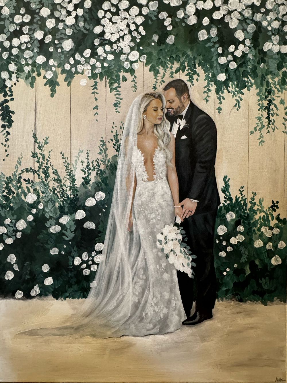 A romantic wedding couple poses under an enchanting floral arch with white roses and cascading greenery.