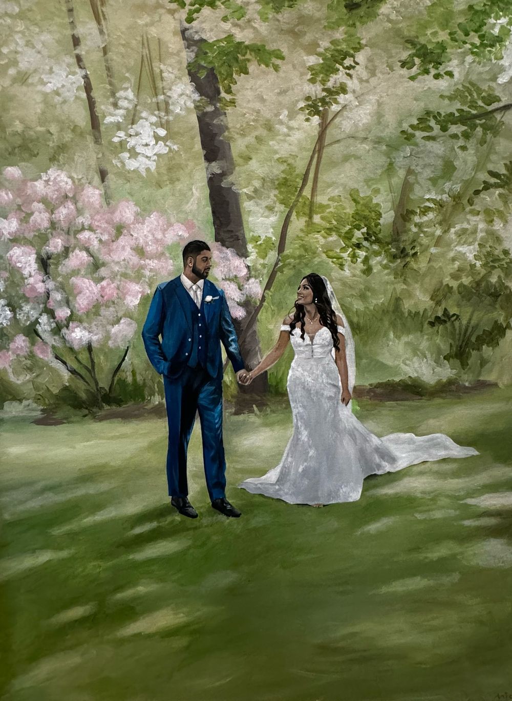 A wedding couple stands in a garden setting with pink blooming rhododendrons and lush greenery in the background.