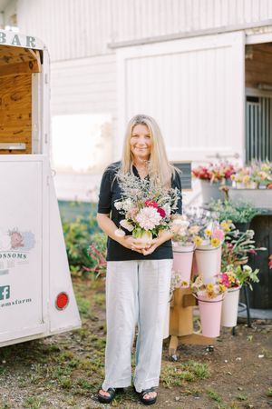 Vibrant floral arrangements in rustic containers displayed at an outdoor garden market setup.