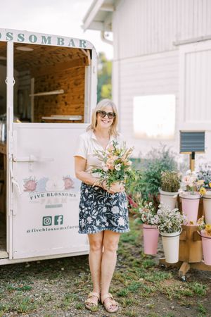 Mobile flower cart with potted plants displayed outside in a rustic garden setting.