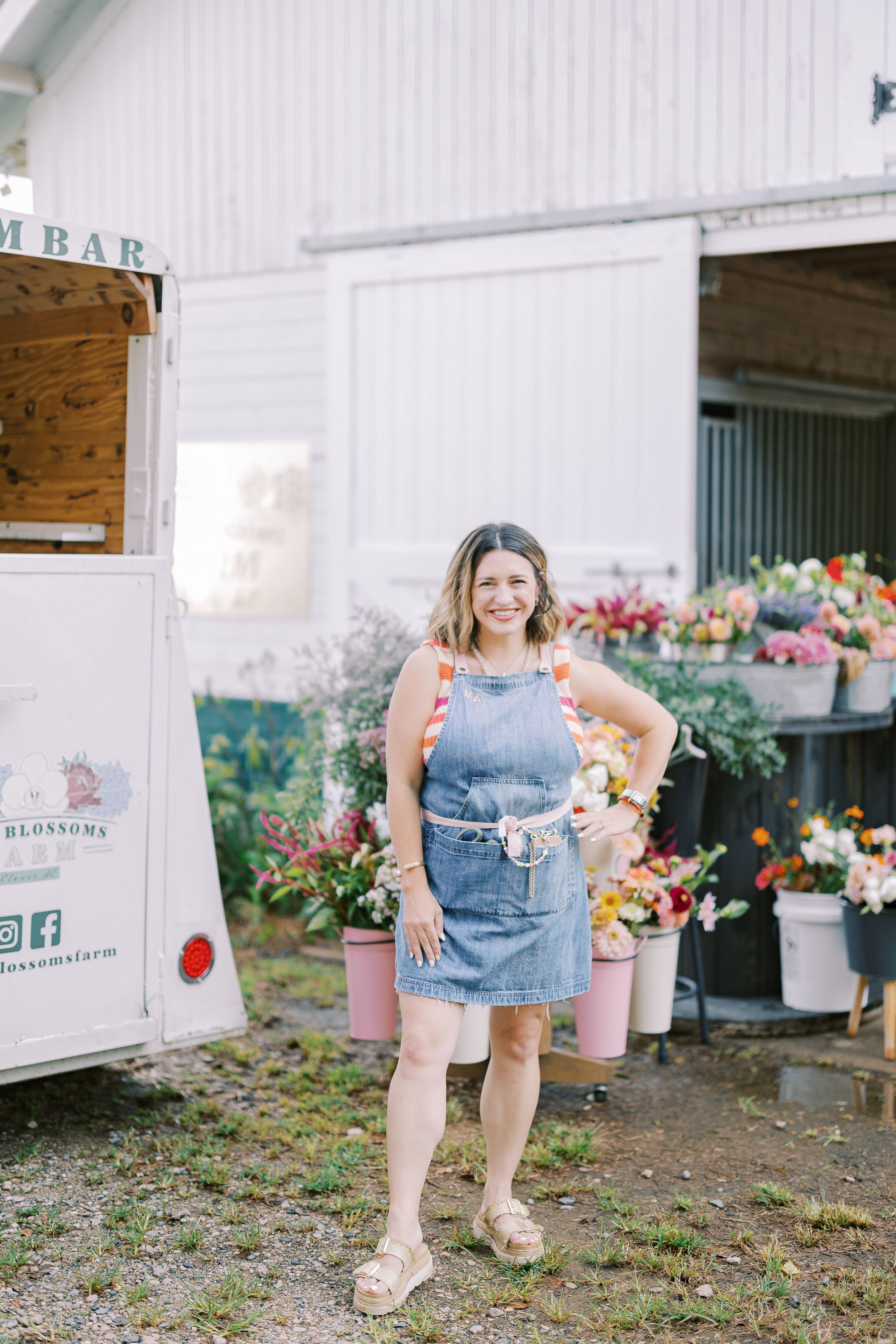 A casual scene outside a flower shop with colorful floral displays and someone in denim overalls.