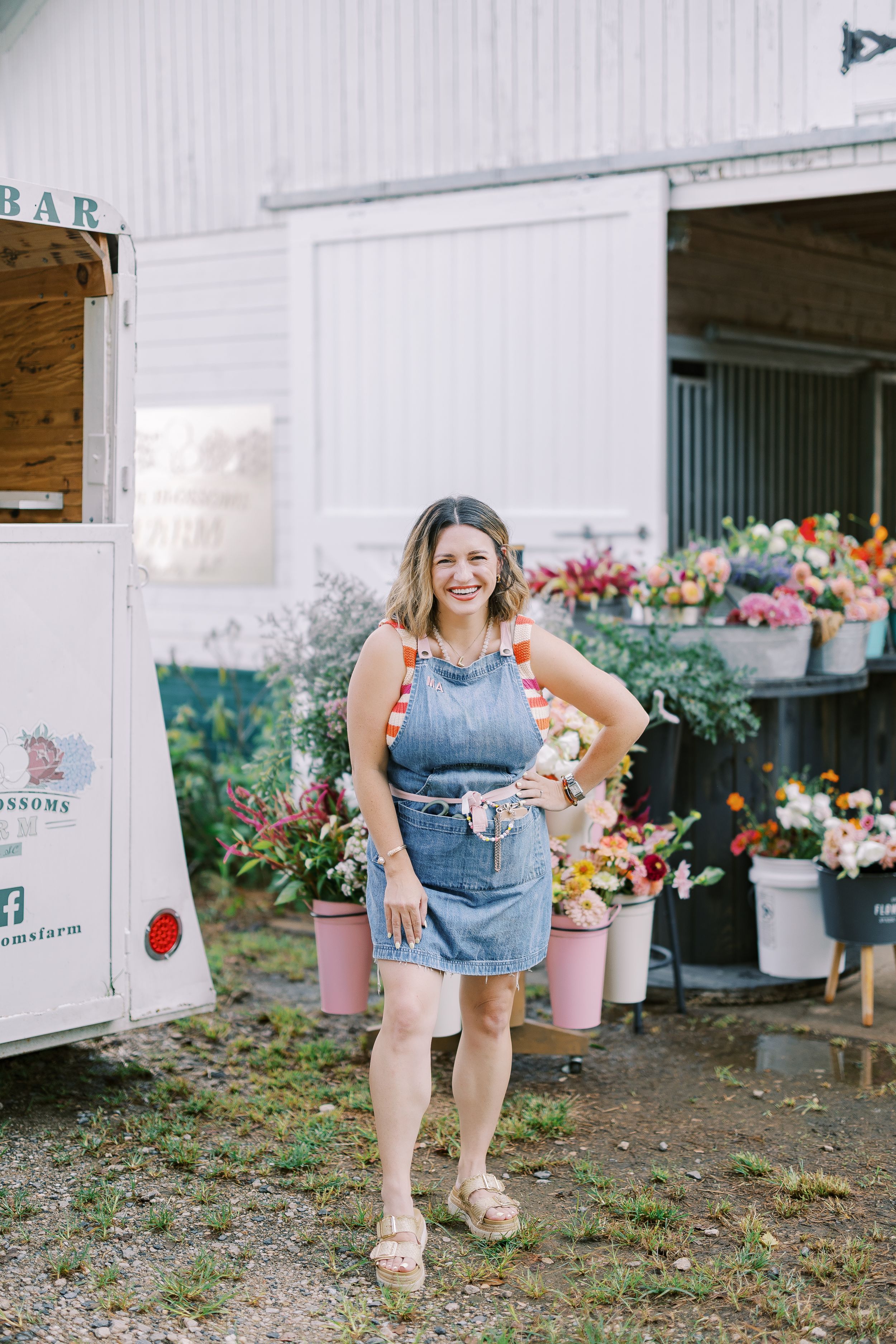 A sequence of someone bending down near colorful flowers and planters outside a rustic building.