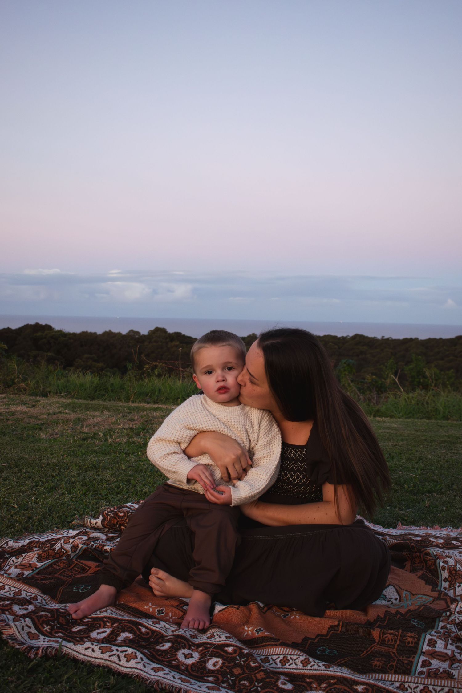 Newcastle motherhood photographer of a mother holding her toddler at sunset