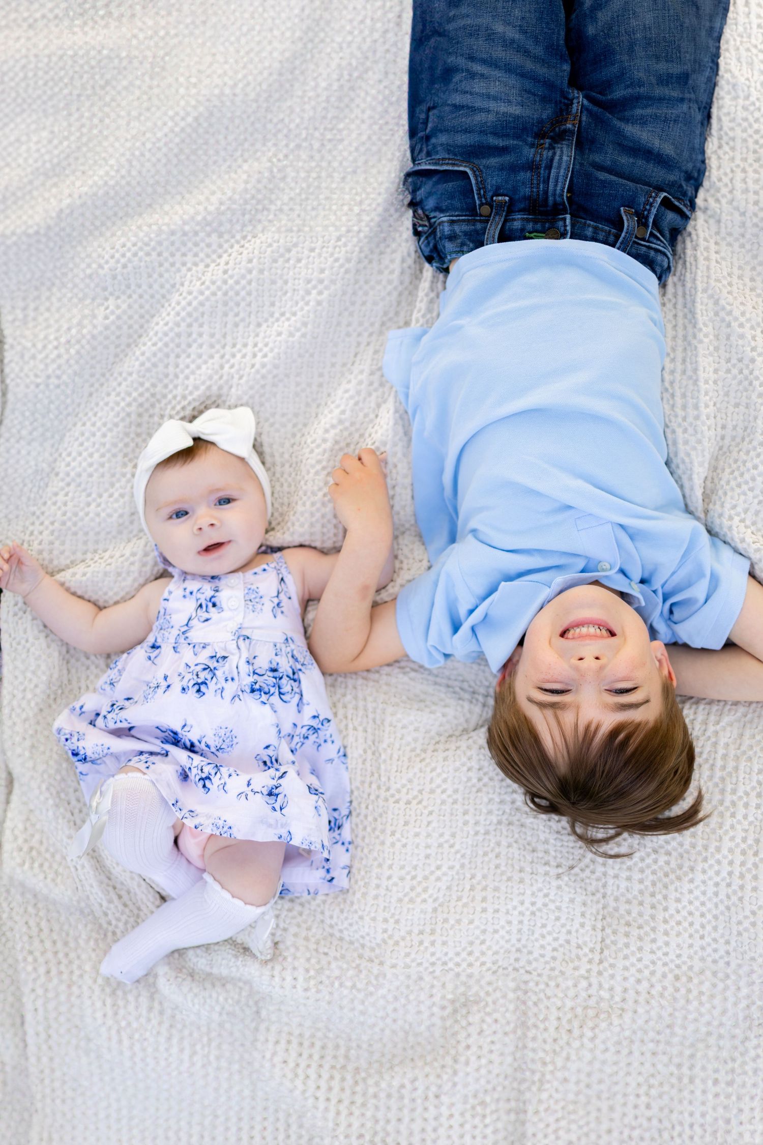 Central Illinois family photographer captures siblings laying and smiling during a photo session in Springfield, IL