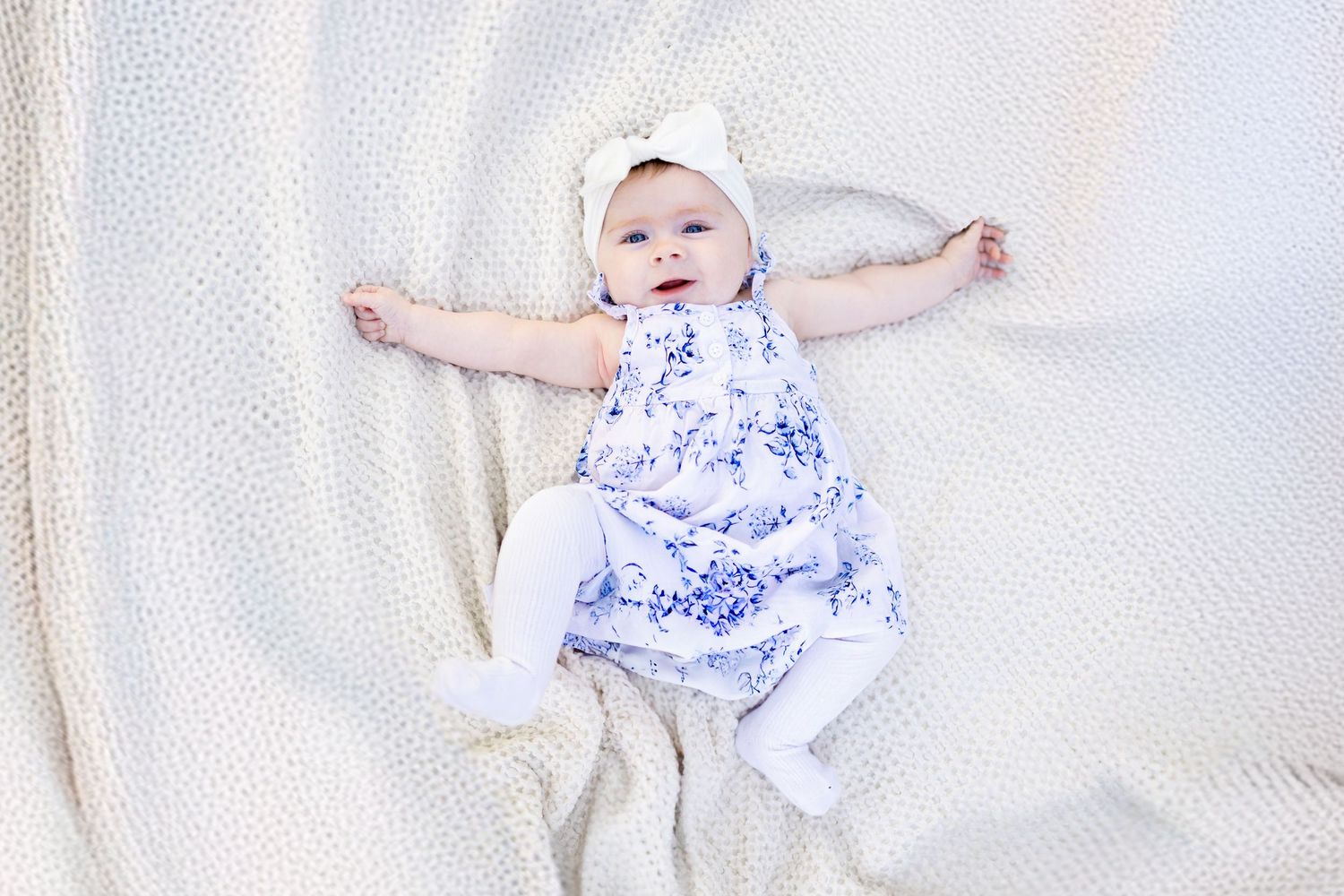 Central Illinois family photographer captures a baby girl smiling laying on a blanket in Springfield, IL