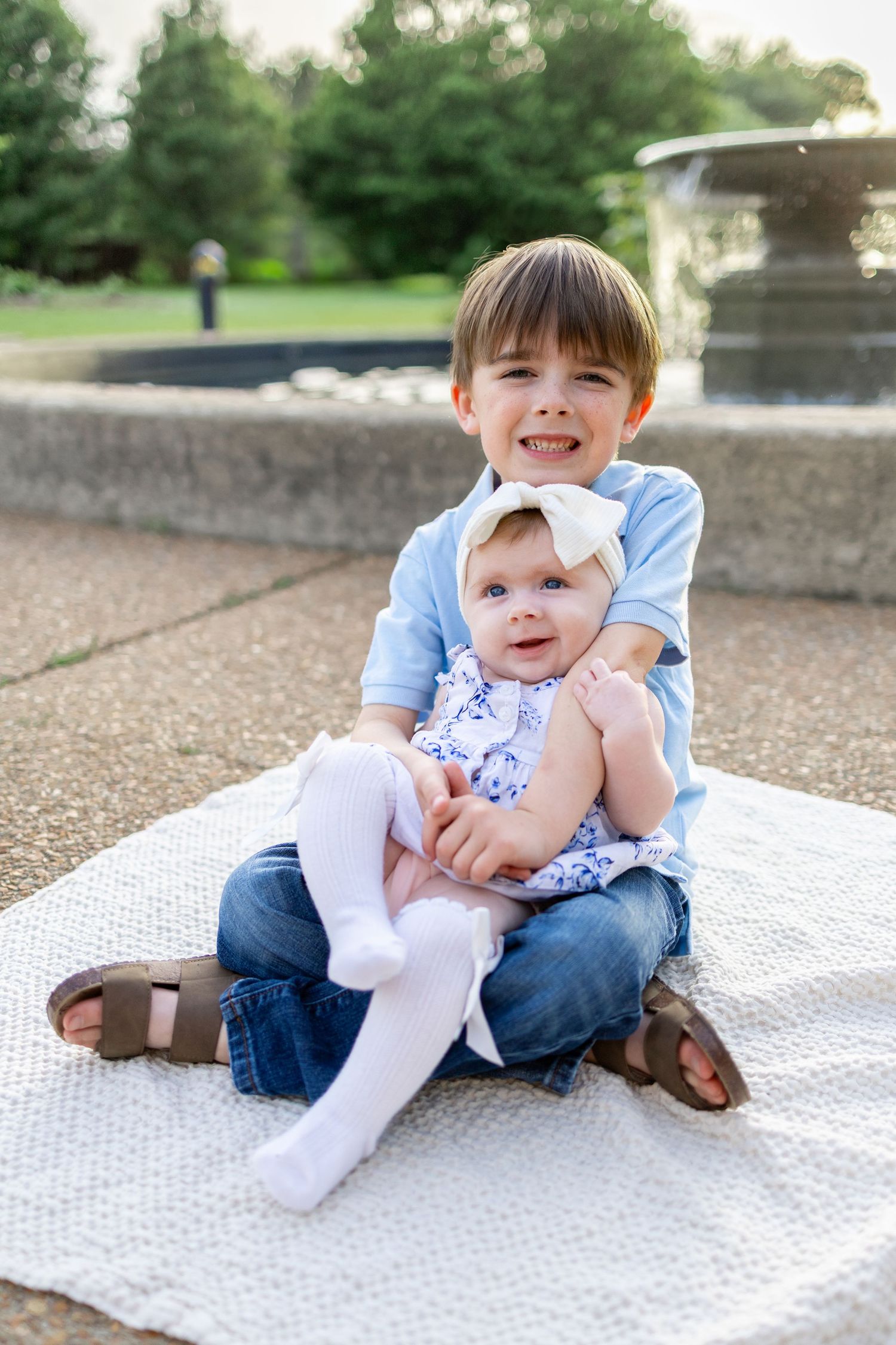 Central Illinois family photographer captures two siblings sitting together and smiling during a photo session in Springfield, IL
