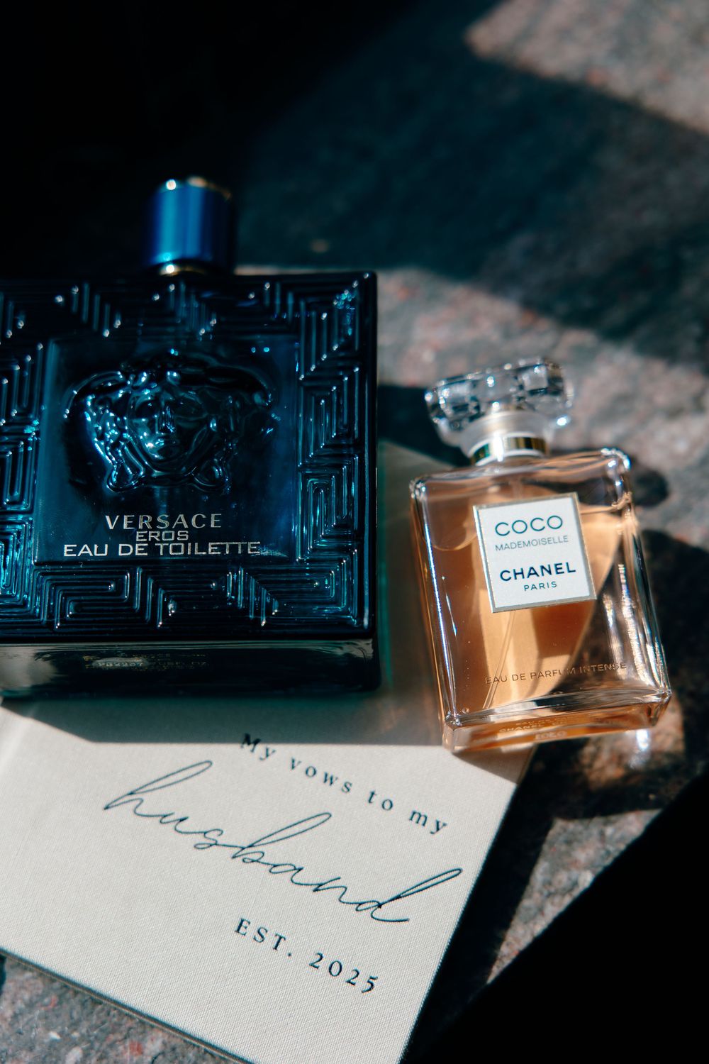 Luxury perfume bottles from Versace and Chanel displayed alongside a card marked 'Est. 2023'.