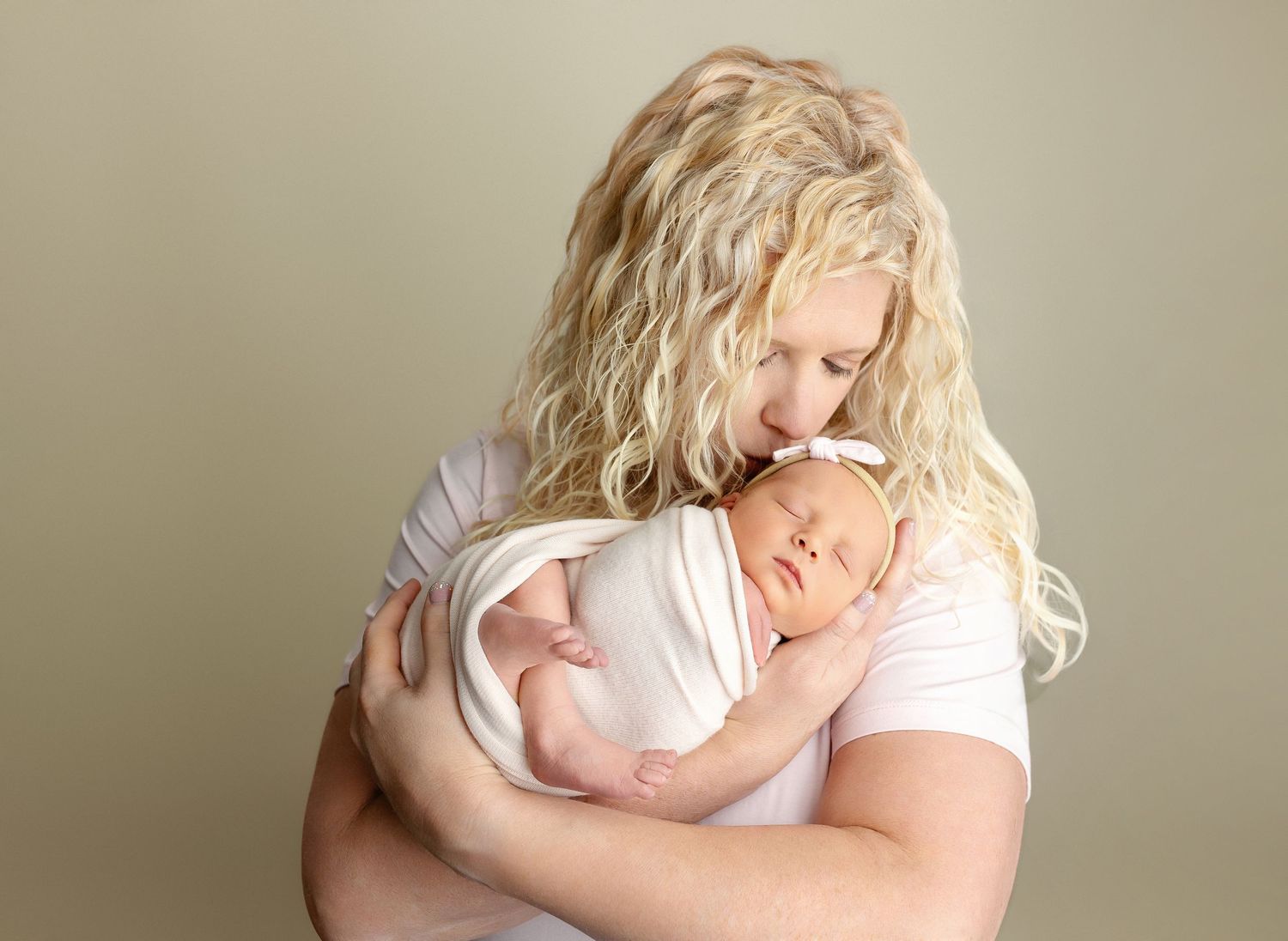 Mom is holding the newborn girl, kissing her on the head. Greenville SC newborn photographer, Easley SC newborn photographer
