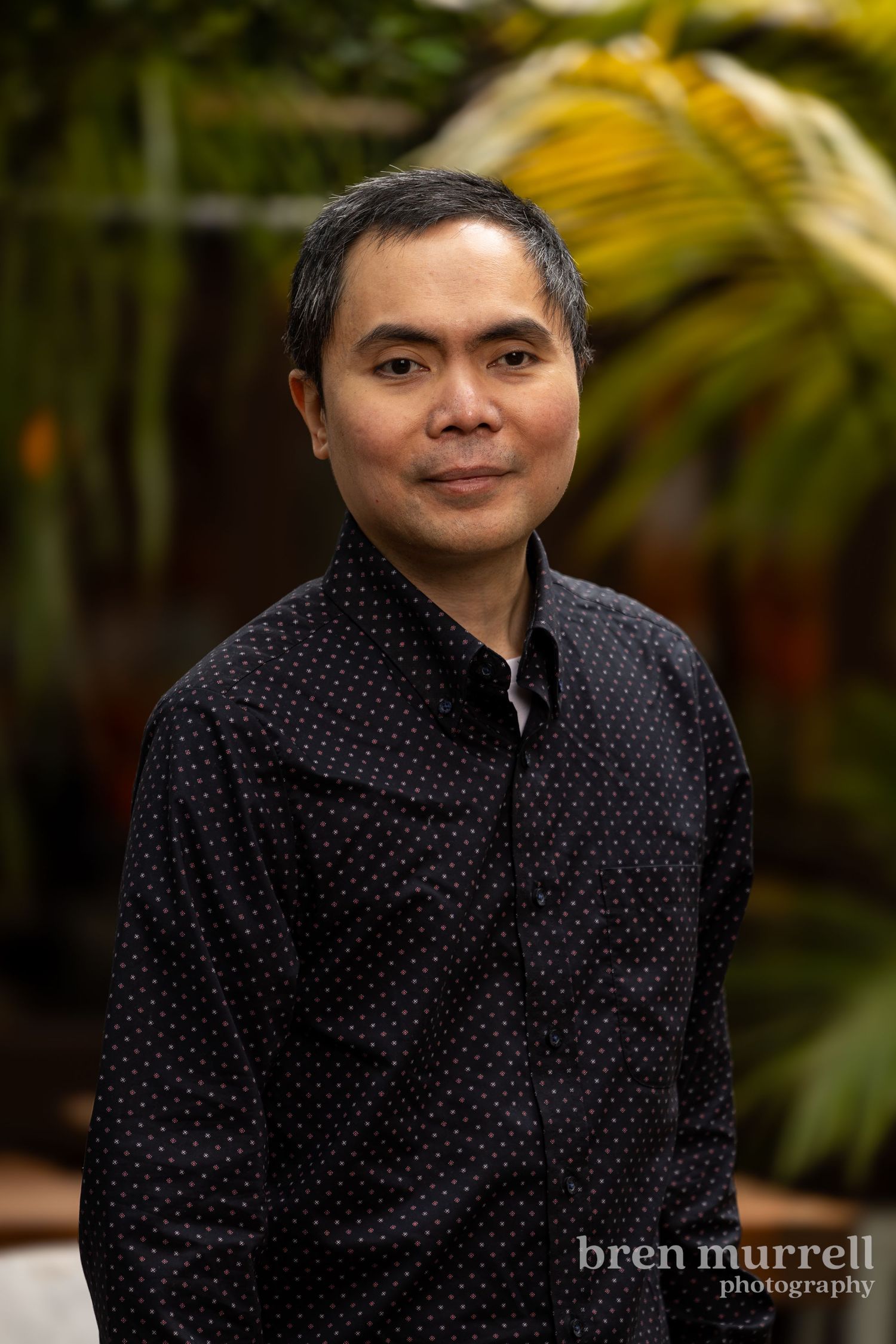 A professional headshot of a Filipino man