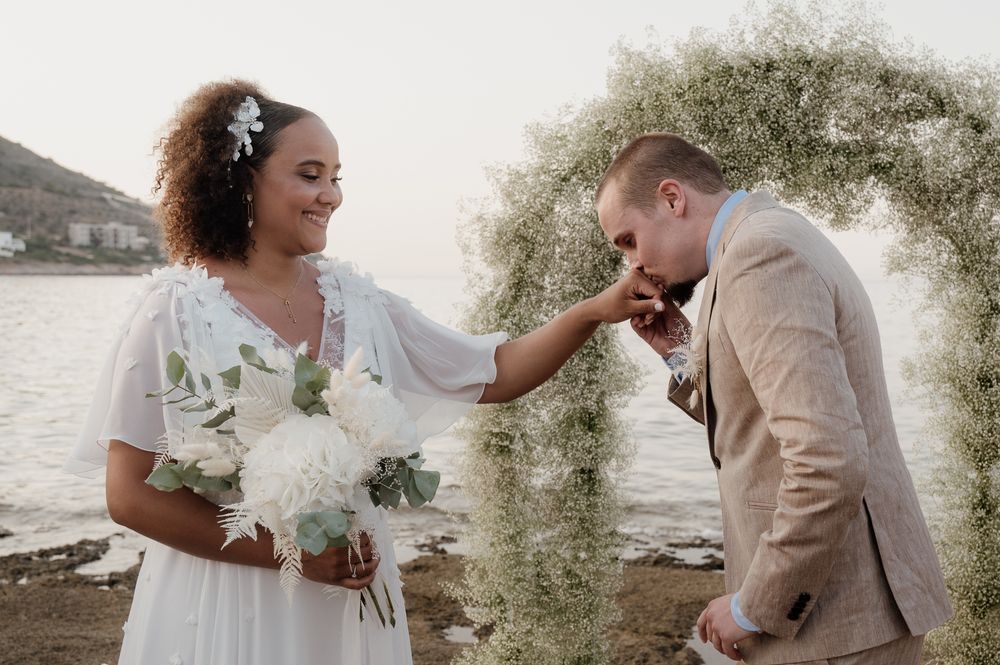 A candid photo of a bride and groom getting married on the beach in Athens riviera Greece