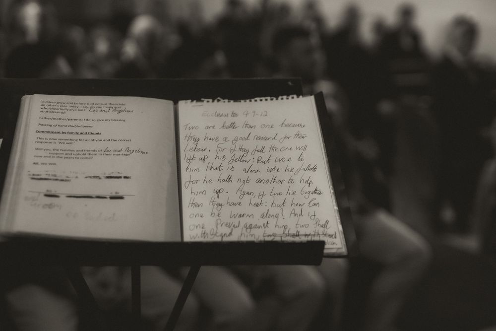 Open notebook with handwritten notes on a music stand, black and white photography.