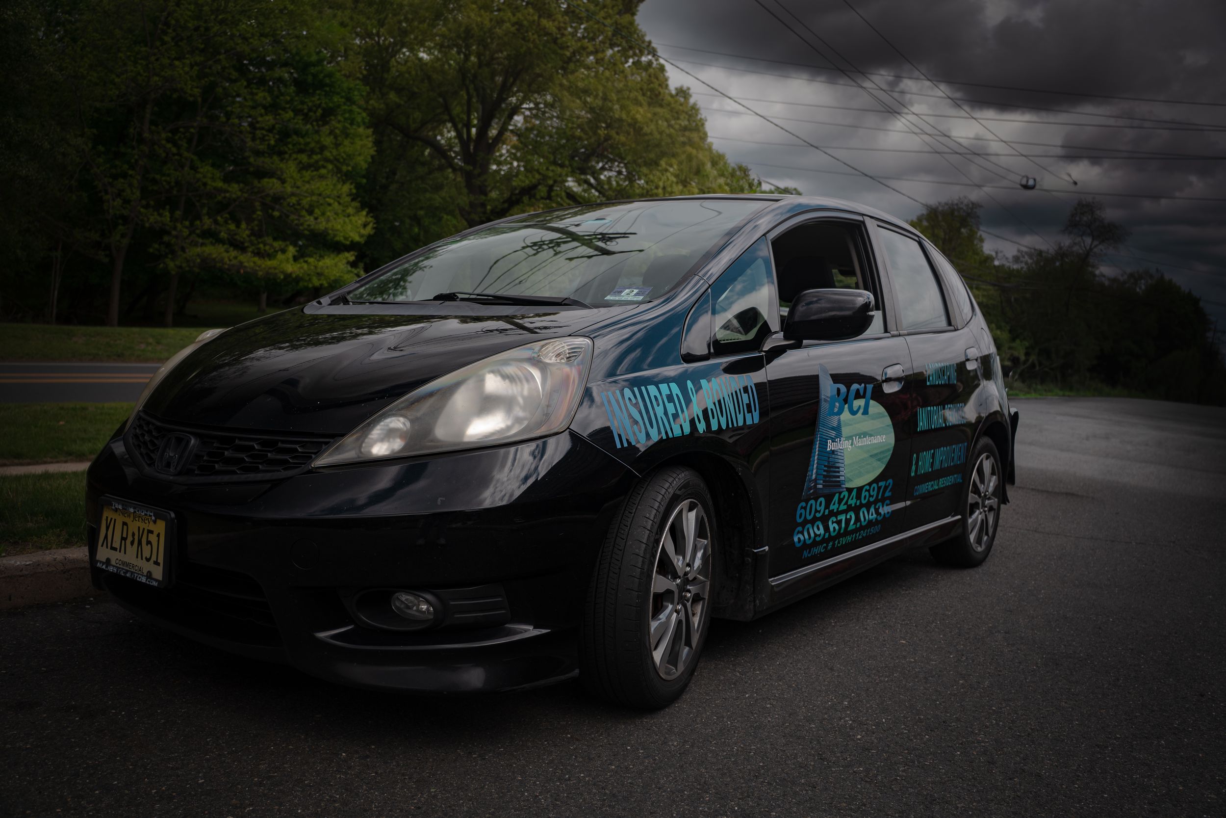 Black Honda Fit with custom vehicle wrap.