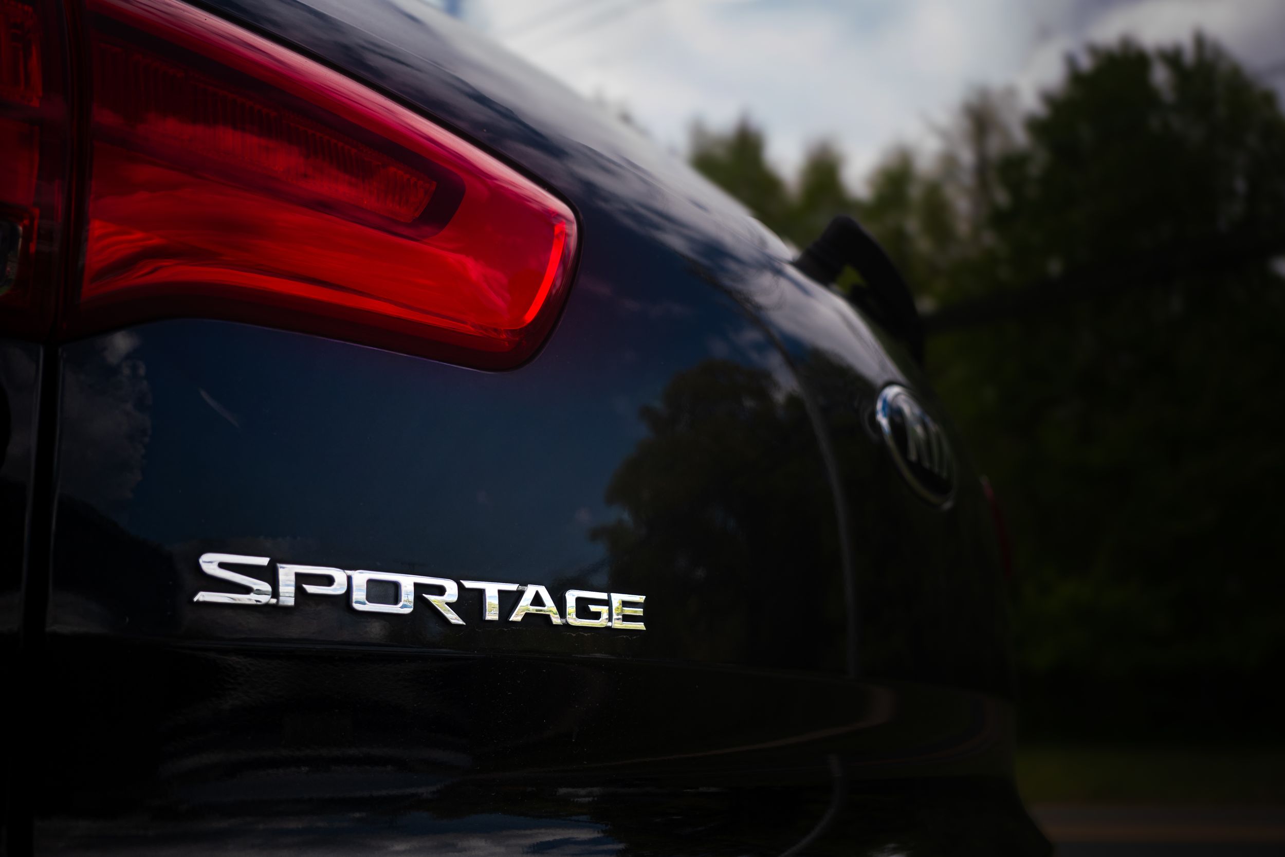 Close-up of Kia Sportage badge.