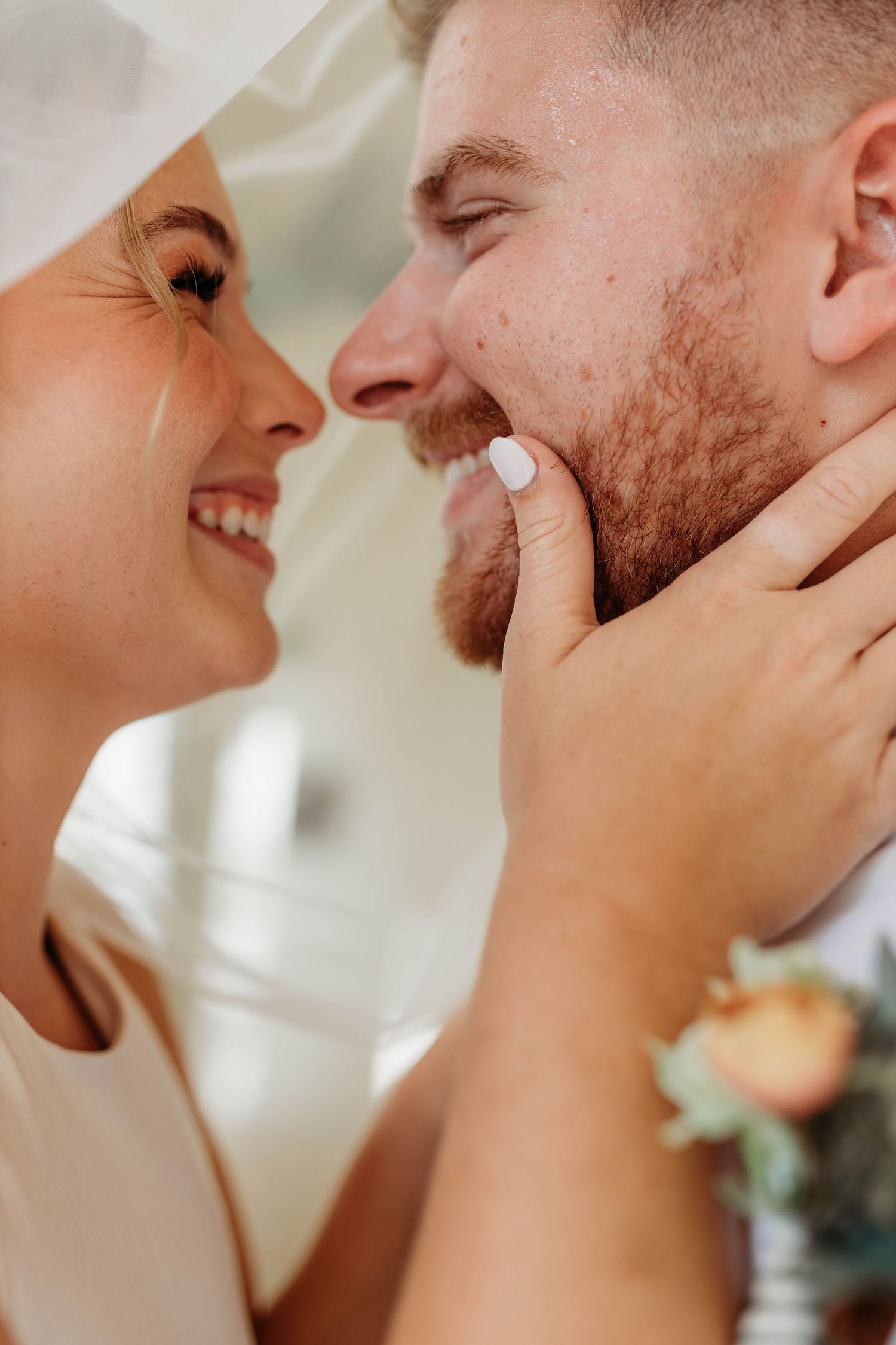 Bride and groom kissing on the beach during a wedding photography session.