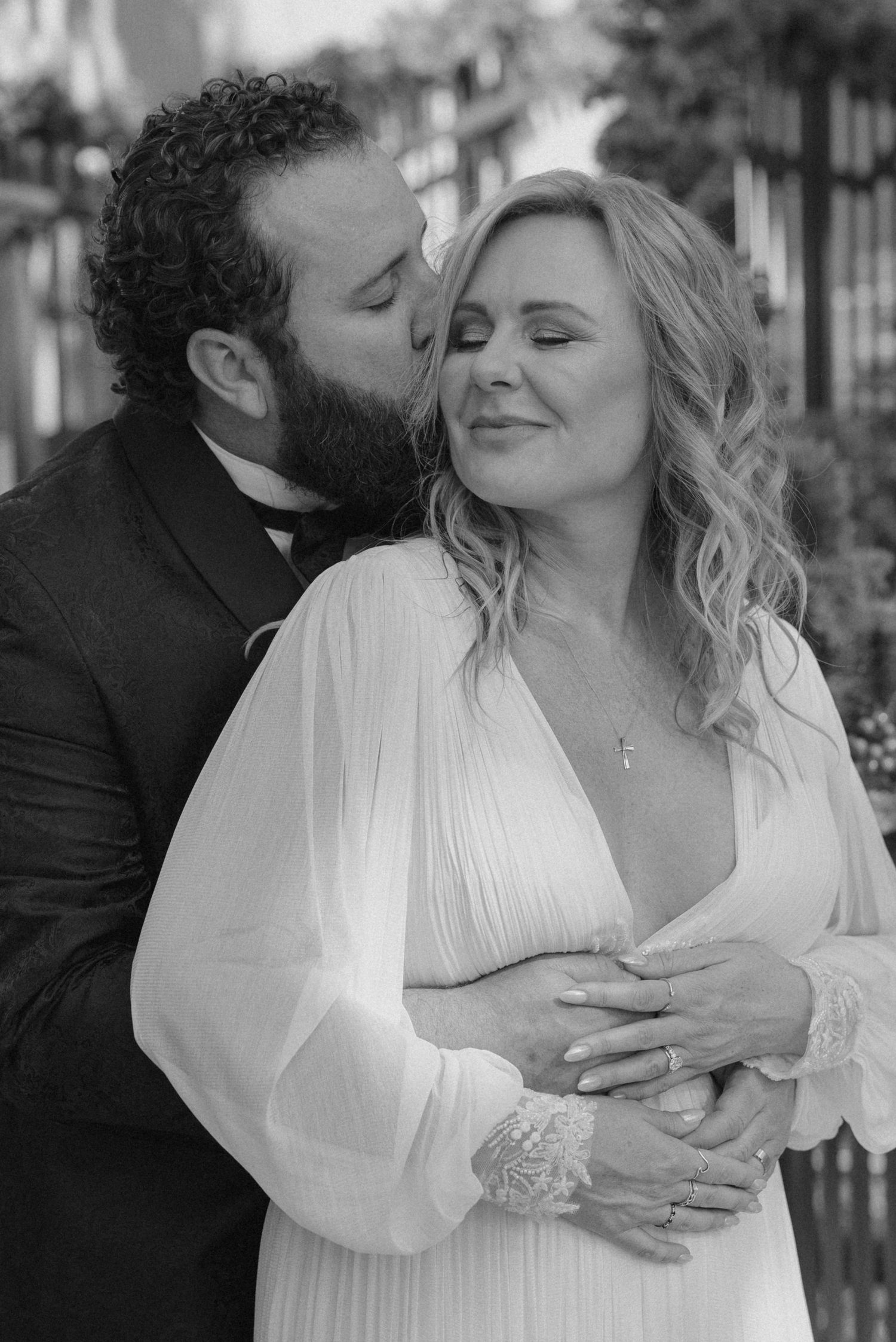 Bride and groom embracing during a wedding portrait in black and white.