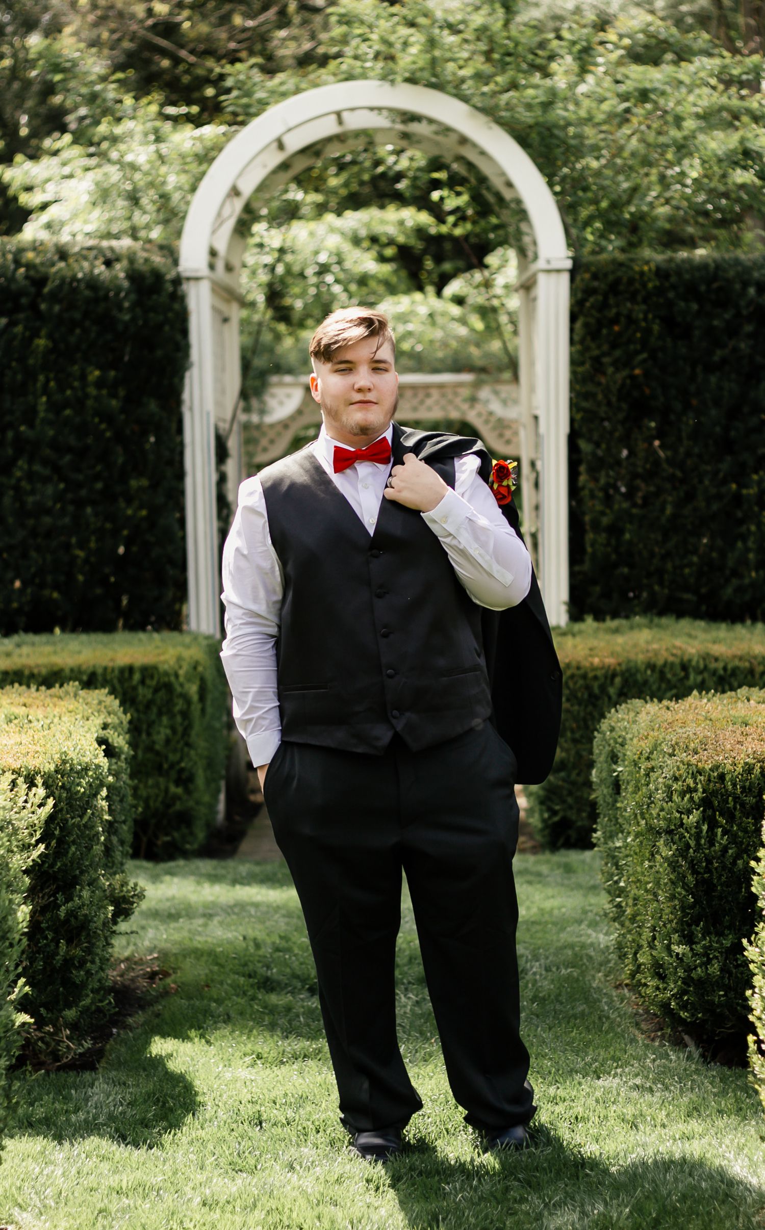 A series of portraits in a garden setting with white arches, featuring formal attire with vests and bow ties.Summer photo sessions Ohio, fal