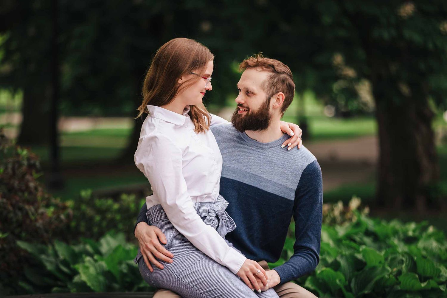 Intimate candid moment of engaged couple smiling and chatting together at the George Robert White Memorial in Boston Public Garden