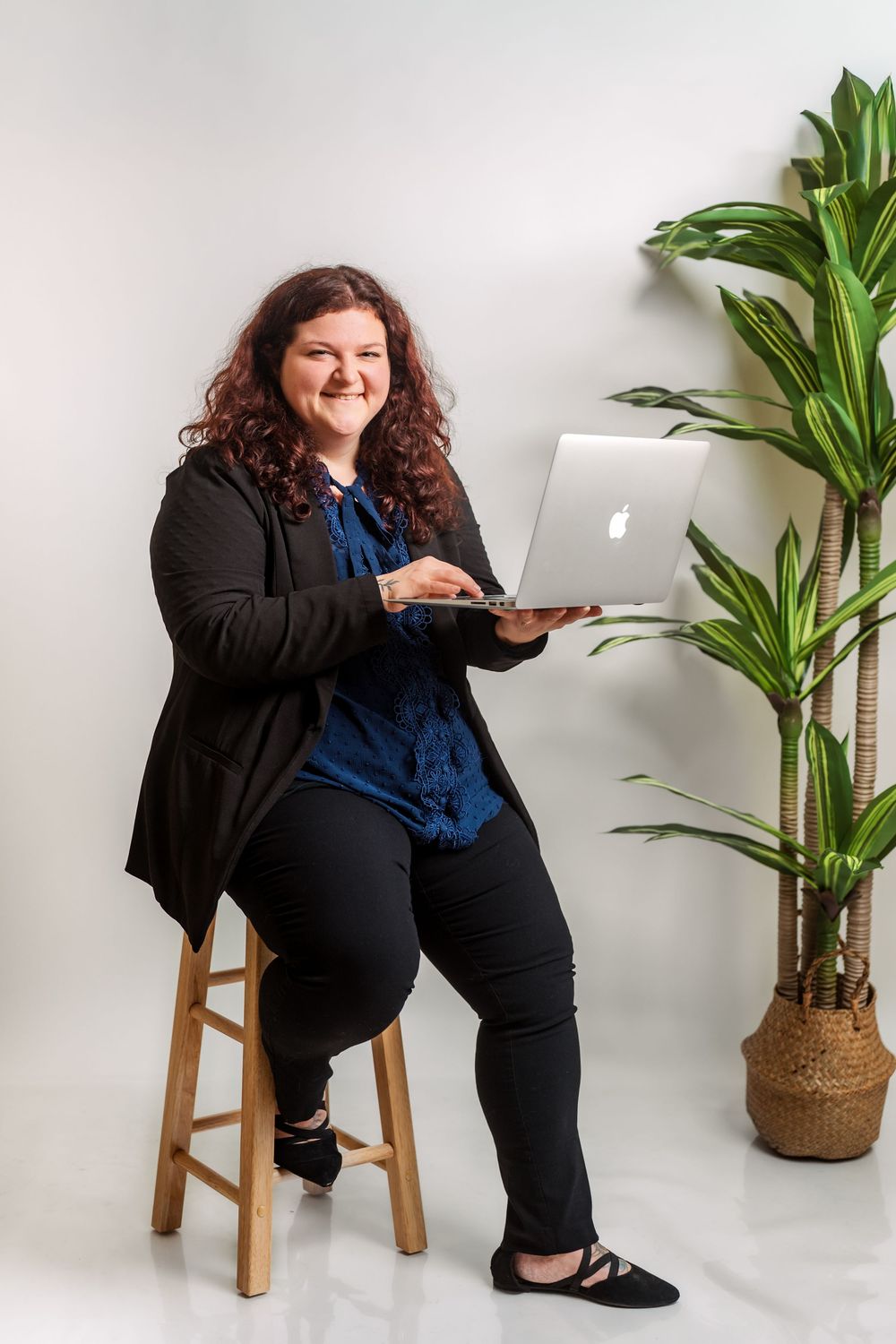 Professional lifestyle photoshoot featuring a laptop and potted plant in a minimalist studio setting.
