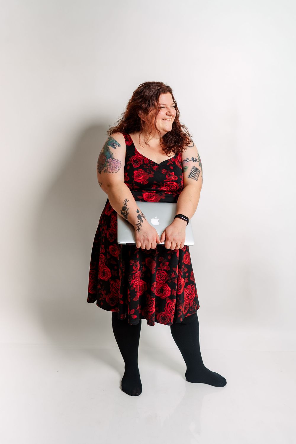 Studio photography session with red and black dress against white backdrop.