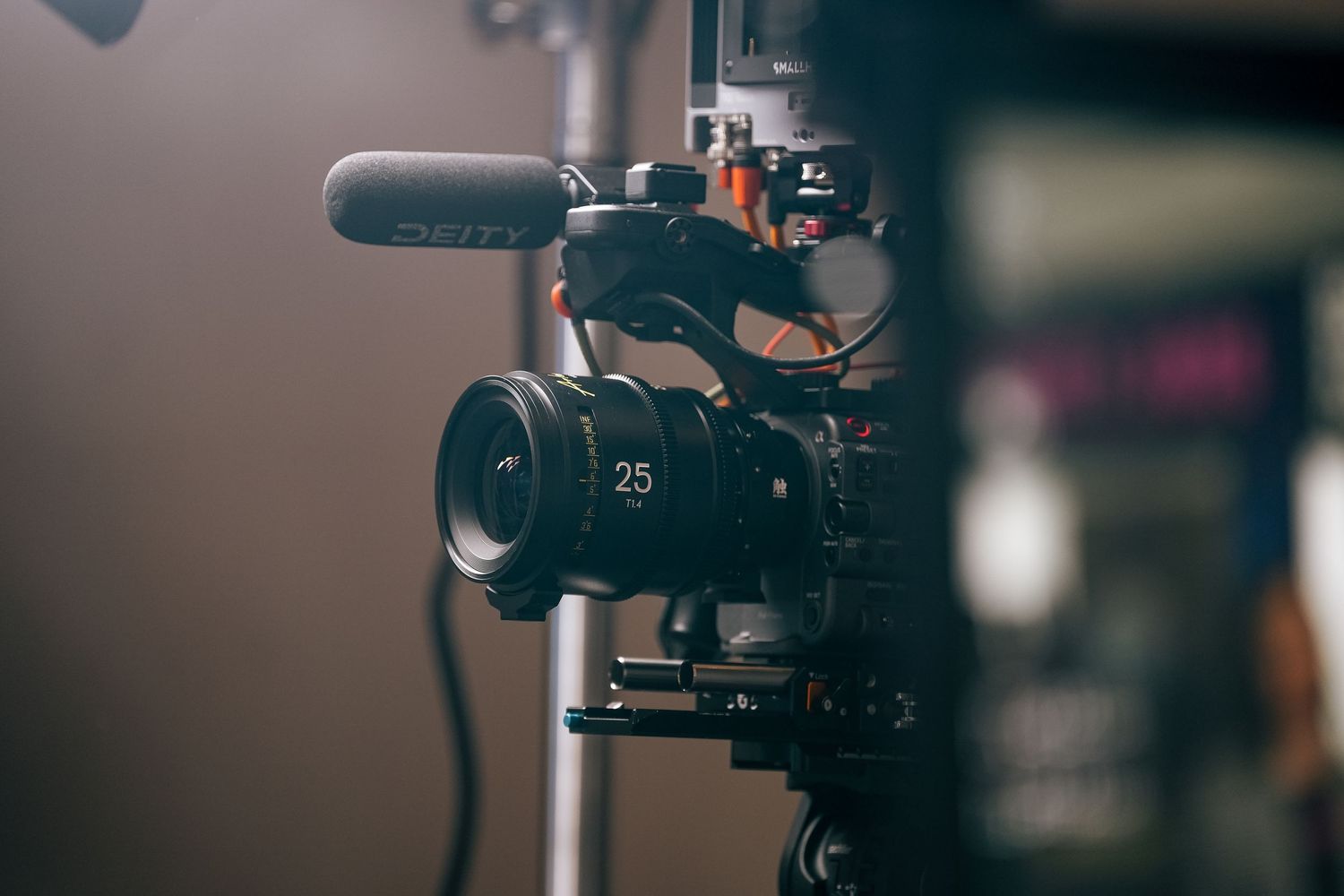 Professional video camera with microphone mounted on a stabilizing rig shown in shallow depth of field.
