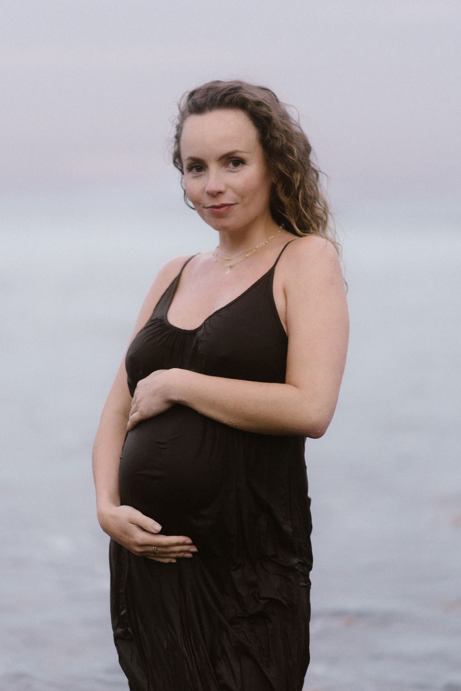 A series of four photos showing a person in a black tank top on a beach during maternity photography session in El Médano, Tenerife.