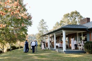 Beautiful outdoor wedding venue with white porch and fall foliage.