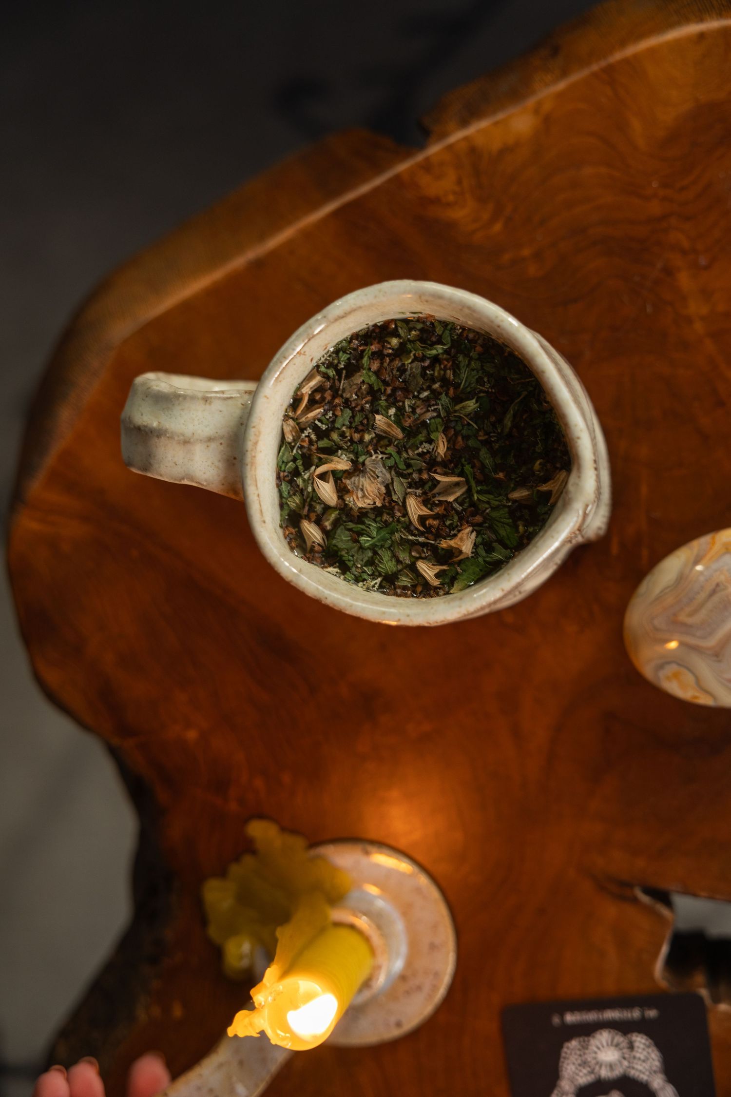 Loose leaf tea for an herbalist and lit candle, crystals, and tarot card for a branding portrait session.