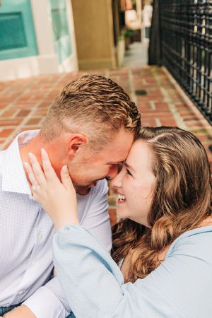 An intimate couple sharing a tender romantic moment together on outdoor steps.
