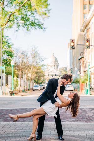A romantic dance sequence of a couple performing an intimate dip pose on a brick paved street.