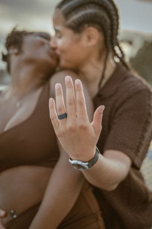 A close-up of hands showing off engagement rings during an intimate moment on a boat.